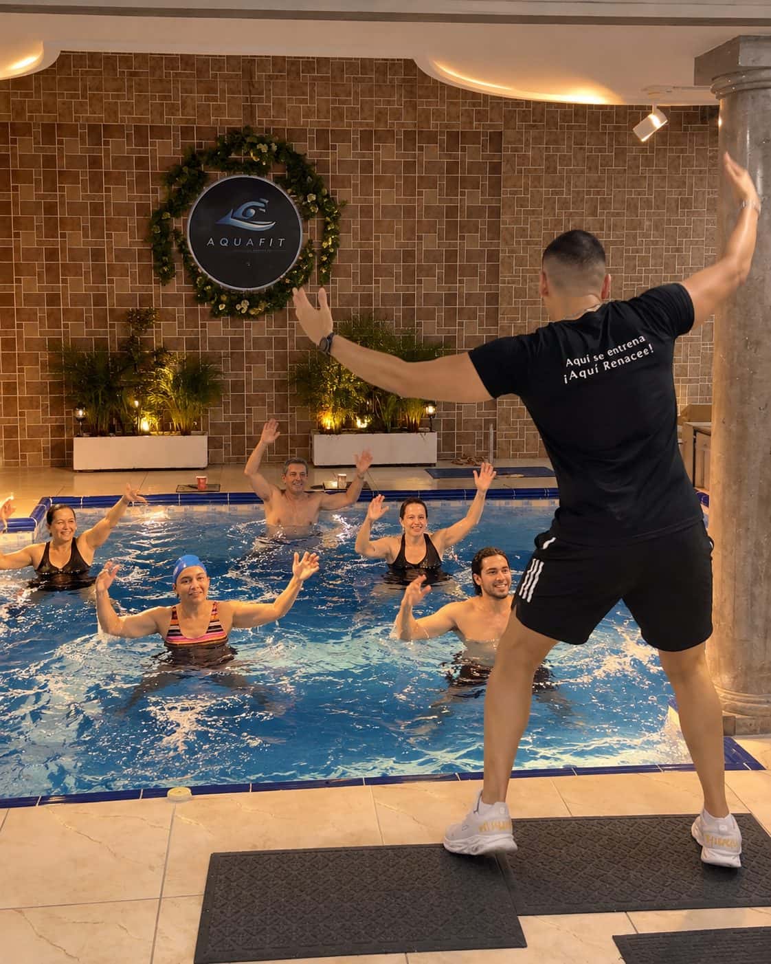 Grupo bailando dentro de la piscina en una clase de Aqua Zumba